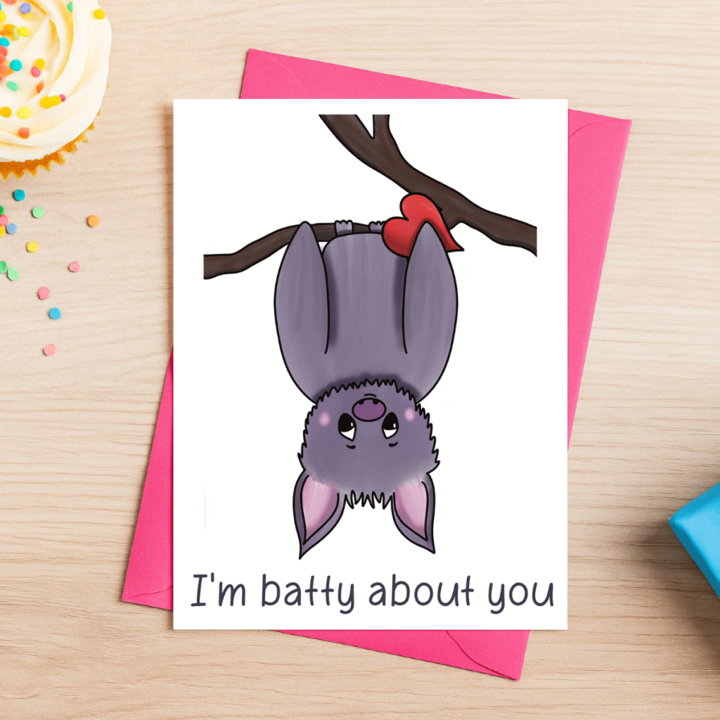 The Batty About You Card features a cute cartoon bat hanging from a branch with a red heart and includes the sweet message “I’m batty about you.” It comes with a pink envelope, perfect for sharing affection on special occasions.