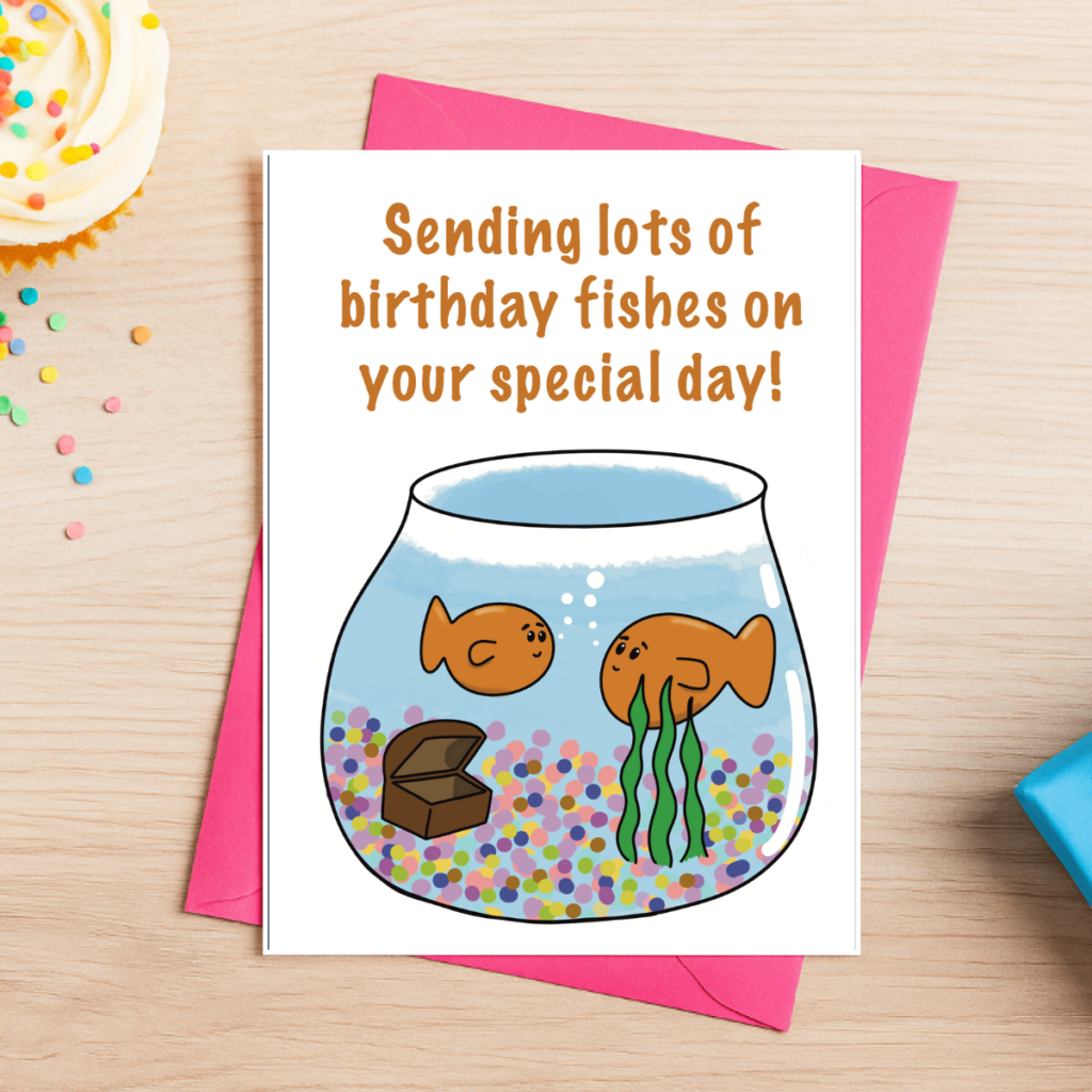 The Birthday Fishes Greeting Card 4 features two cartoon goldfish in a bowl with pebbles, a treasure chest, and seaweed. It reads “Sending lots of birthday fishes on your special day!” and comes with a pink envelope.