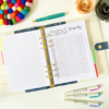 The Sleep Tracker Planner Insert 4 displays a sleep log chart with dates and hours, surrounded by colourful pens, a felt ball coaster, and decorative paper flowers on a white surface.
